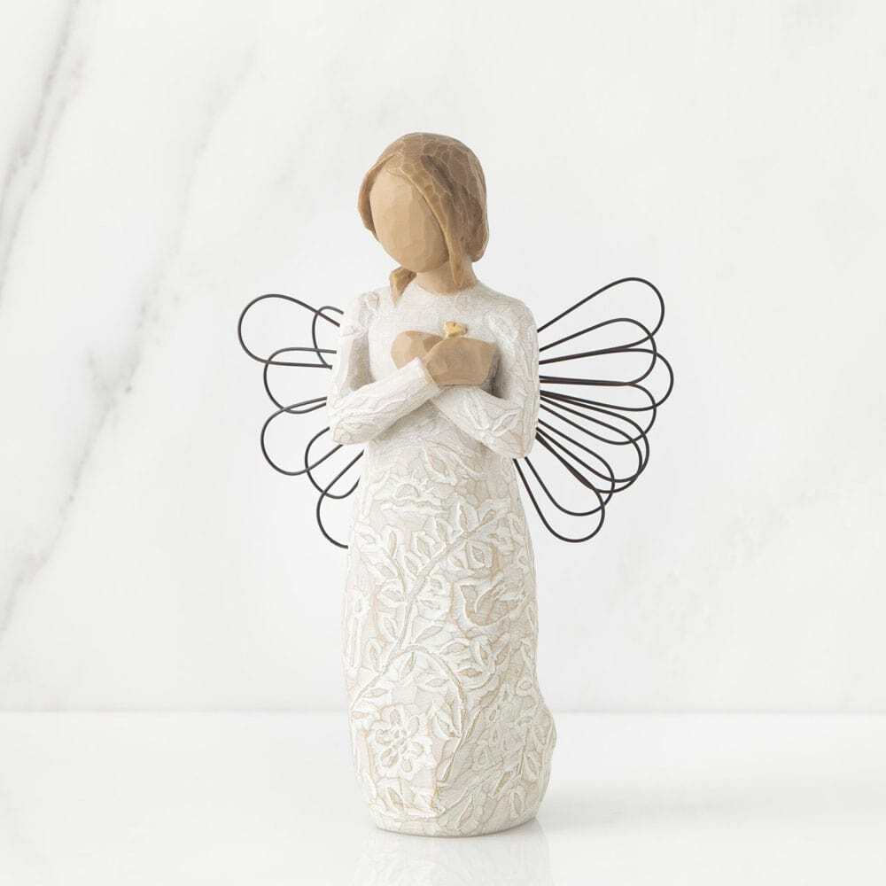 Standing angel in cream dress with wire wings, with crossed hands under small gold-leaf heart. Dress carved with symbols of nature