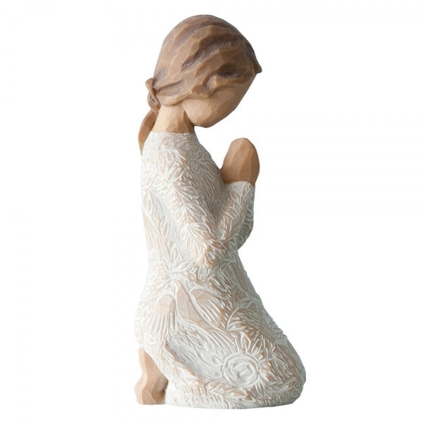 Kneeling female figure in cream dress with hands in prayer pose. Dress is heavily carved with birds and flowers