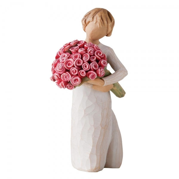 Standing female figure in cream dress holding large bouquet of pink roses