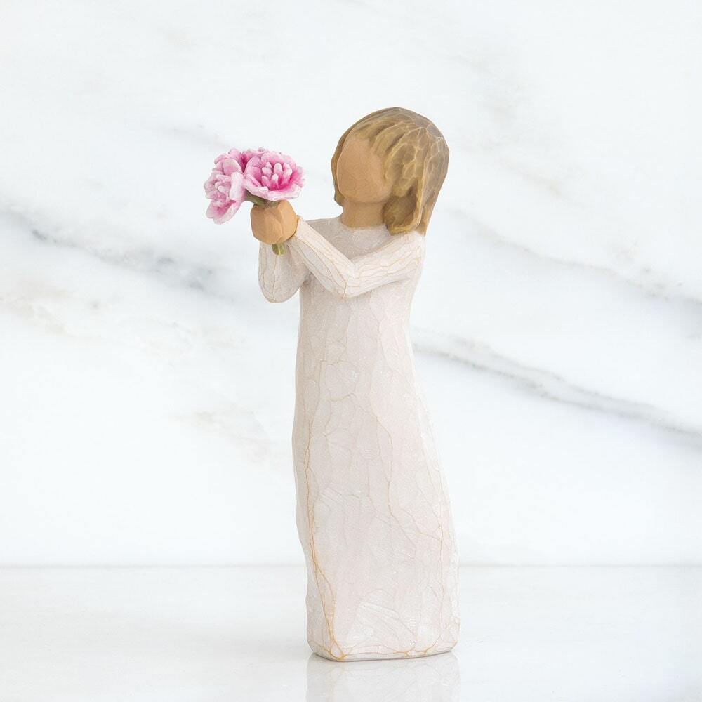 Standing figure in cream dress, holding out small bouquet of pink peonies