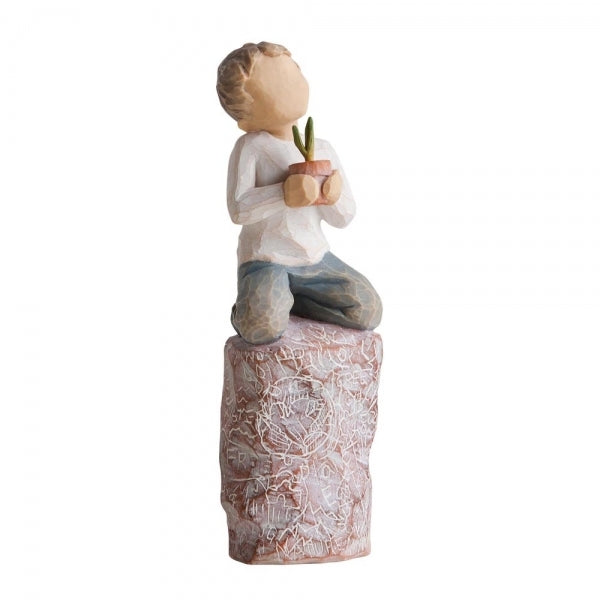 Figure of small boy in cream shirt and blue jeans holding a small green plant in terracotta pot, kneeling on tall red rock, etched with words and imagery of earth, nature and puzzle pieces