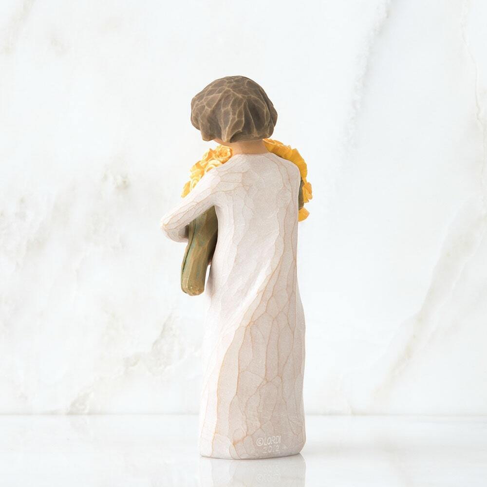 Standing figure in cream dress, holding large bouquet of yellow roses in her arms