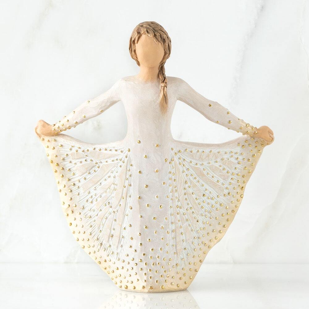 Standing figure in cream dress, holding the sides of her skirt out with both hands. Skirt has carved markings of a monarch butterfly, dotted with gold leaf